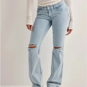 lågmidjade jeans, nelly - snyggaste ljusblå, lågmidjade jeansen med hål på knäna, från nelly!! jättefint skick, endast använda några enstaka gånger. nypris är 699kr❤️❤️