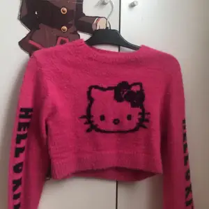 En rosa lurvig hello Kitty tröja. Ganska kort 