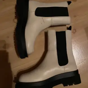 Ett par beige boots från Gina Tricot. Köpte 2021 men blev aldrig att jag använde de, sen dess har de bara stått. Har ett litet märke på som var när jag fick hem de. Jag säljer dessa för 250kr + frakt. Storlek 39. 