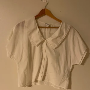 Vit blus med krage som har lite spetskanter  - Superfin blus i storlek S