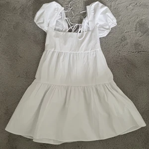 Klänning - Vit klänning i storlek M från märket Stradivarius. Använd en gång och i bra skick. Perfekt till sommaren.