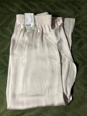 Härlig sommarkjol! - En kjol i silke med slits på bägge sidor. Helt ny i typ krämvit