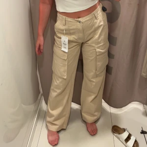 Bershka cargopants - Snygga cargopants i beige från bershka. Inköpta i Spanien i somras. Strl 38. Aldrig använda, därav är skicket som nytt. Köpare står för frakt
