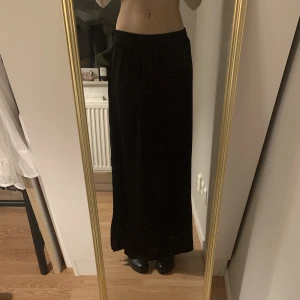 Svart maxi kjol - Säljer denna svarta kjol från Vila! Lite lång på mig som är cirka 171cm, men supersnygg! Perfekt till sommaren☀️