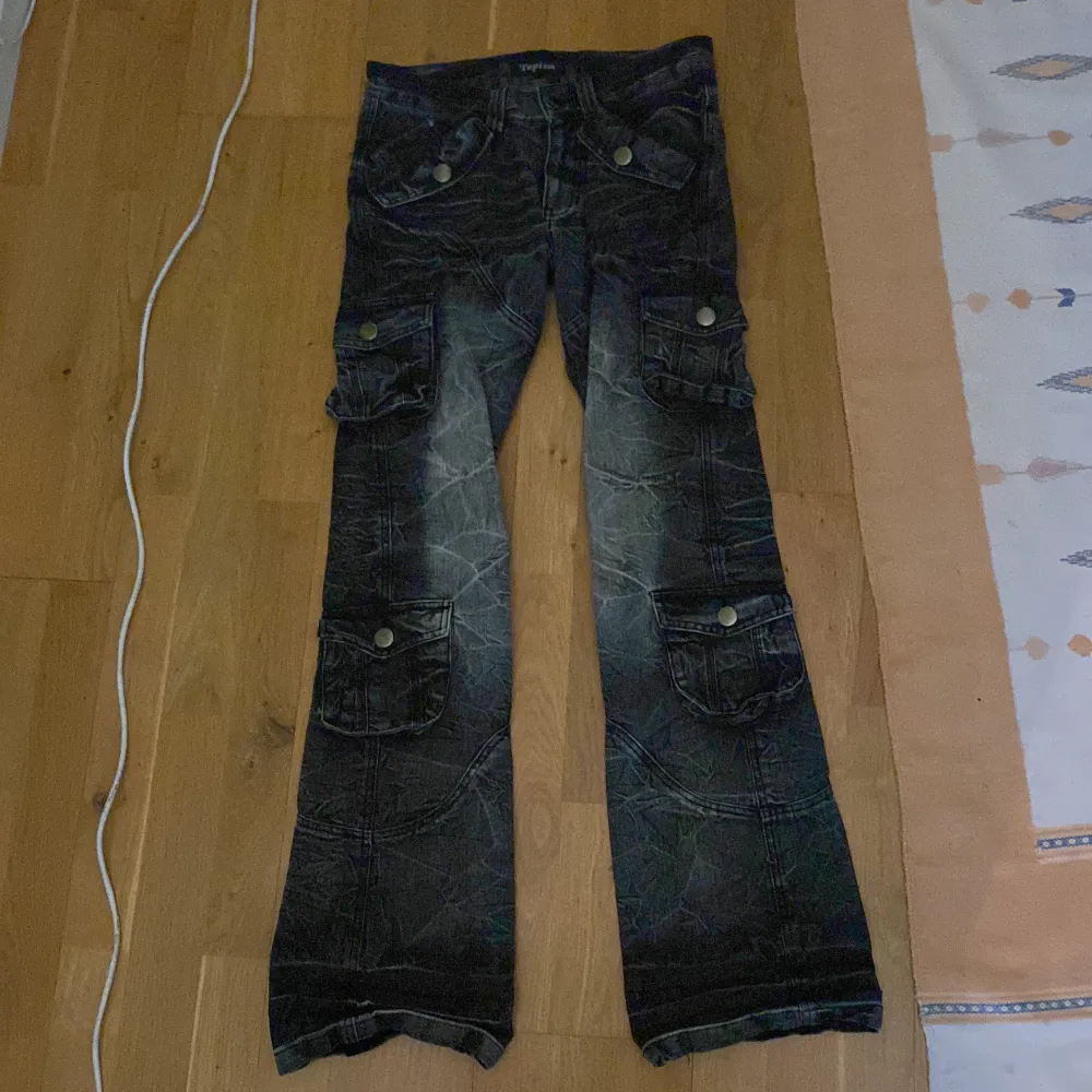 Säljer ett par japanska cargo-jeans i storlek 28/29, de är bootcut med en low rise och har massa snygga detaljer Midja: 76cm Rise: 22.5 cm Längd: 101cm Benöppning: 23cm. Jeans & Byxor.