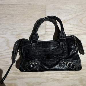 Säljer denna klassiska svarta väska. Det är den minsta modellen och har inga defekter alls. Till väska tillkommer ett längre svart band. 