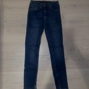 Stretchiga högmidjade jeans med slits. Sitter superfint på och är bekväma. Passar någon som är 166cm eller kortare. Använd 1-2gånger(nyskick). Pris kan diskuteras😊