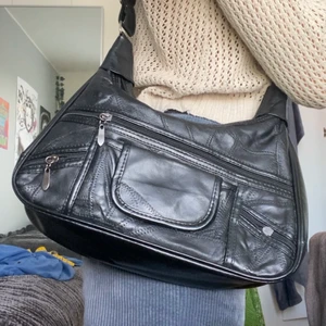 SVART LÄDER AXELREMSVÄSKA - BUD ÄR BINDANDE. As fin vintage axelremsväska. Har varit en staple, men säljer pga att jag har för många väskor. Rymlig och har två stora fack. Banden är reglerbara. Kan bli shoulderbag! Väskan är 30 cm i bredd. Fraktar och möts upp🖤 spårbar frakt 51 kr.