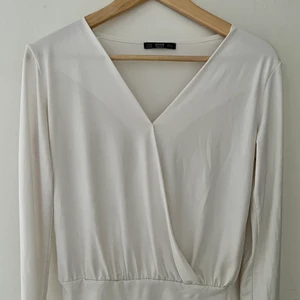 Blus Dilvin - Vit, v-ringad body från Dilvin. Dam strl M. Jättefint skick, knappt använd.☺️