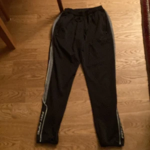 Träningsbyxor  - Fatpipe. Svarta med grå ränder på sidorna,xs.