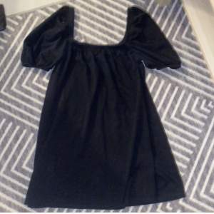 En kort svart och luftig klänning med fina armar. Använd ett fåtal gånger. 
