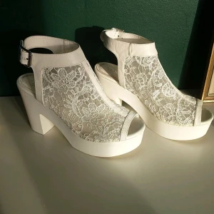 Klackskor - Vita klackskor med spetsdetalj. Säljer för att jag inte gillar att använda högklackat. Har använt ca. 4 gånger och dom är i väldigt bra skick. Original pris- 400 kr.