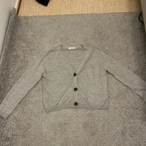 En grå kofta - En grå kofta i storlek M. Har använts ett par gånger men den är ändå i bra skick. Frakten står inte på mig.