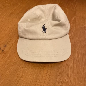 Ralph lauren keps  - Säljer denna ljus beiga Ralph lauren. Var inte rädd att kontakta mig om du har frågor. (Kan byta mig annat)