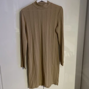 Midiklänning  - Midiklänning i beige/sand. Otroligt skönt material som omsluter kroppen på rätt ställen.  Köpt ifrån Nelly i storlek L