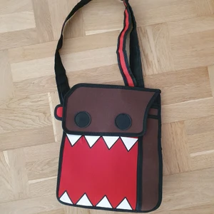 Domo axel väska - En Domo väska med ganska mycket utrymme för dator eller några böcker och annat. Har två fickor och är justerbar. Använd bara en gång för några timmar  Säljer då den ej passar mig riktigt. 