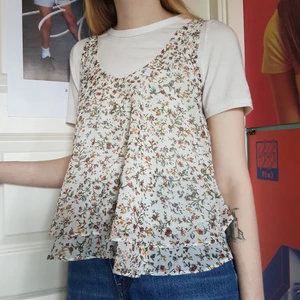 Blommigt linne - Jättegulligt blommigt vitt linne, väldigt flowy. Passar bra att ha över en annan tröja eller som den är. Storleken säger XS men jag skulle säga att den är mer som S. Obs! den vita tshirten ingår inte.