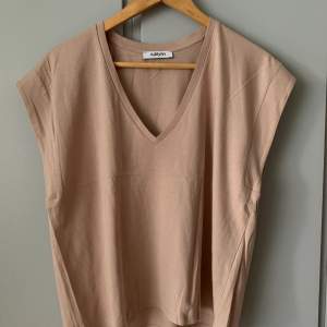 En T-shirt i färgen gammelrosa, loose-fit med ett lätt tyg som faller fint.