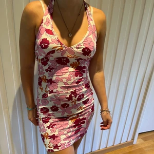 Blommig rosa klänning - En rosa tajt halterneck klänning ifrån shein, använd några få gånger, superstrechigt och mjukt material, köparen står för frakten💞