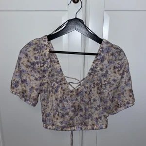 Croptop - Blommig croptop från H&M. Aldrig använd. Har en knytning i ryggen ( kan skicka bild privat vid behov). 170 +66 (frakt) 