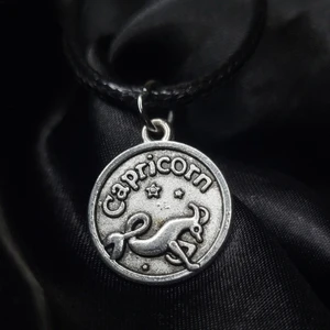 Capricorn Halsband! ♑  - Egengjort halsband med stjärntecknet stenbock/capricorn berlock! Framsidan visar stenbocken tillsammans med stjärntecknets namn på engelska, medan baksidan visar tecknet samt en egenskap associerat med folk födda i tecknet. 45cm långt men justerbart.