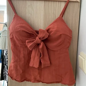 Topp XS-S-M? från Grekland - Denna hittade jag i en charmig butik i Grekland. Kort Linne/Topp med rosett som man knyter själv. Baksidan är låg och ”räfflad”. Passar xs och S, möjligtvis en mindre M. Pris + frakt. Kan även mötas i Södertälje 