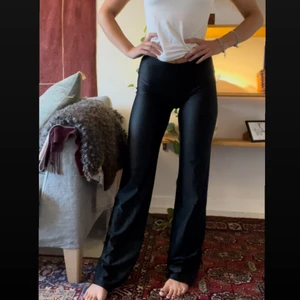 Svarta bootcut tights - Perfekta tightsen i coolt glansigt polyester. Sitter uppe skitbra och lägger sig dunder. Jag är 165cm💯💯