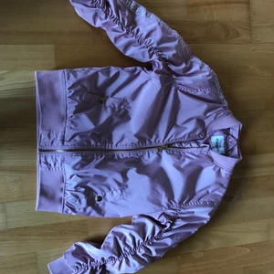 Tjej jacka vackert rosa - Rosa snygg bomberjacka med textremsa på armarna i storlek 149 från KappAhl💗 Mycket bra skick. 