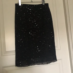 Vintage skirt strl M - Glittrig kjol i oanvänt skick från ca 15 år sedan från märket Hennes Collection. Stretchig midja och tyg. Köparen står för frakt.