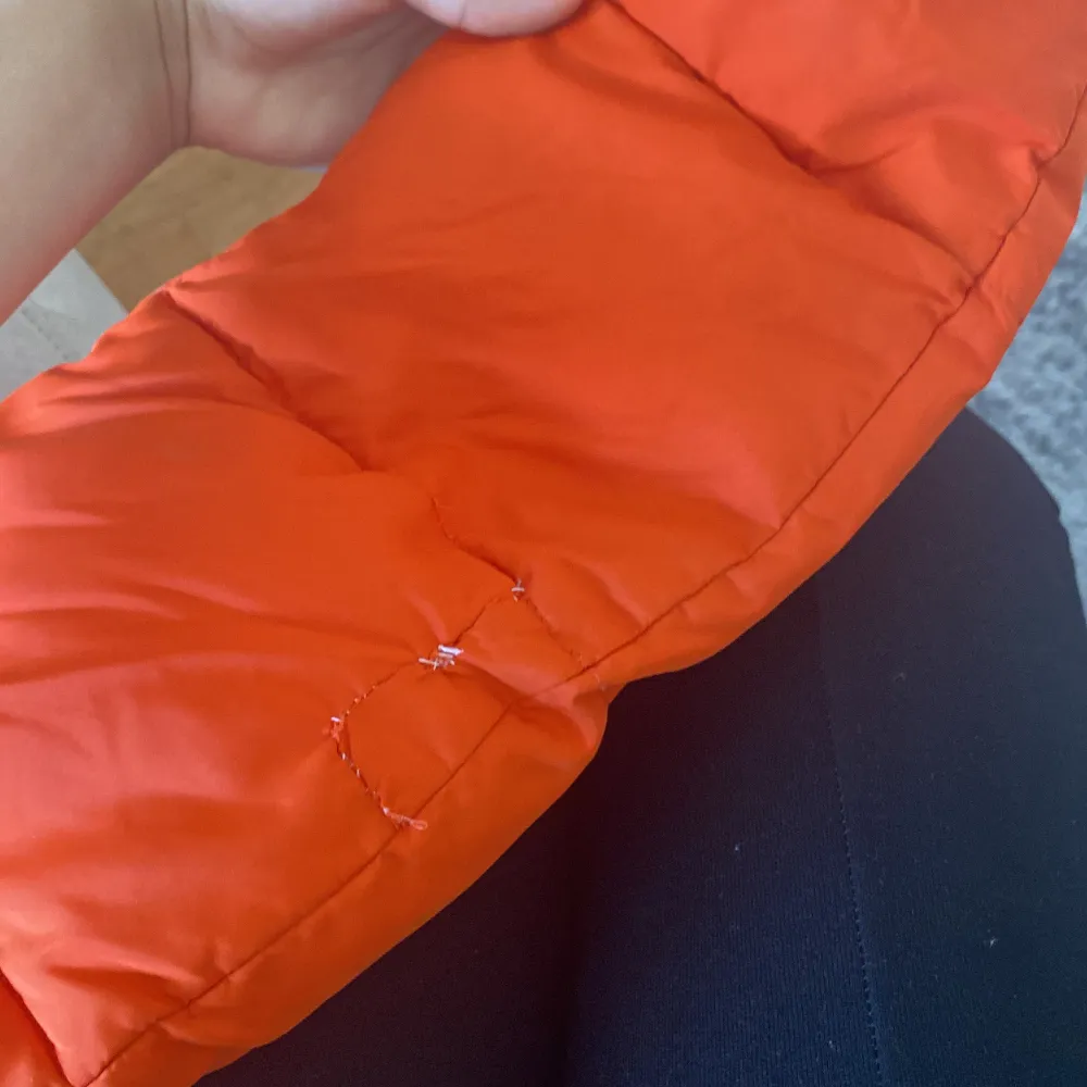 En orange vinterjacka i storlek 134,lite trasig i sidan av armen men sydd.. Jackor.