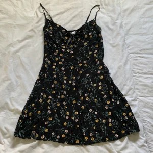 Blommig klänning - Jättesöt ”minidress” som går att styla som den är eller med en långärmad tröja / t-shorts under. Gulliga blommor på. 