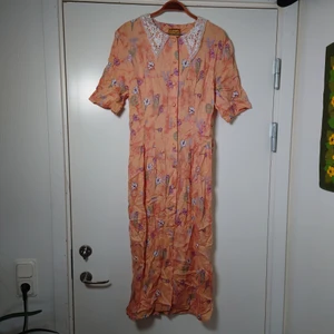 Vintageklänning  - Lång vintageklänning i ljus orange med spetskrage och knappar hela vägen🌿