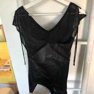 Topp - Glittrig seethru topp med snörning på axlarna