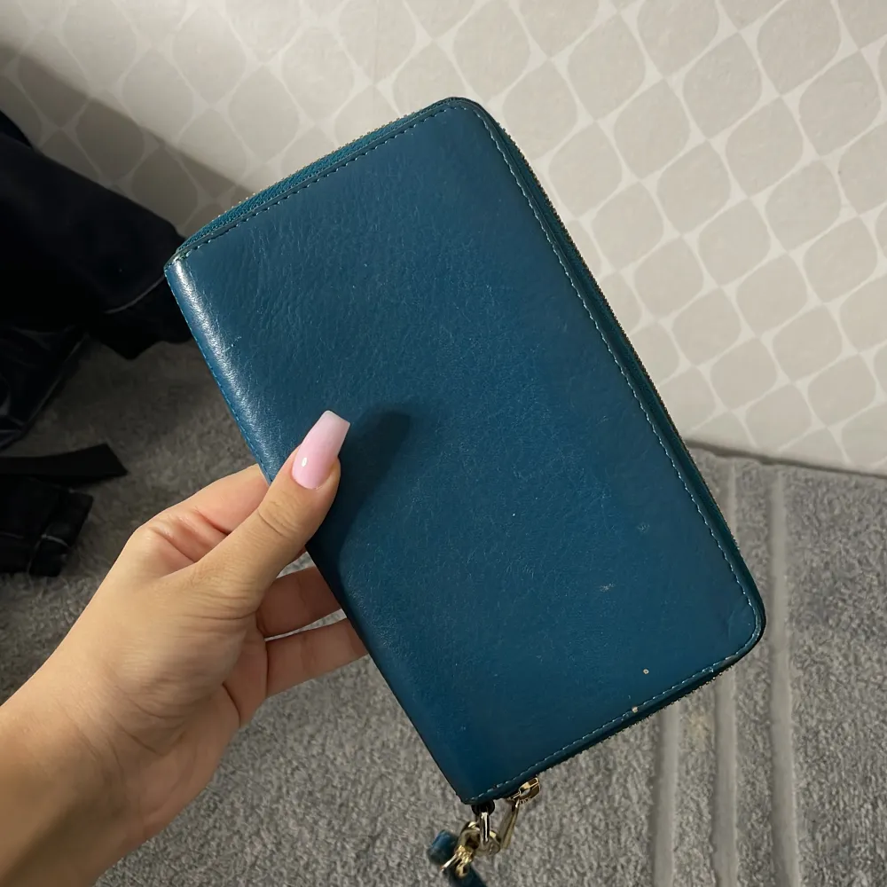 Plånbok i grön/blå färg. Accessoarer.