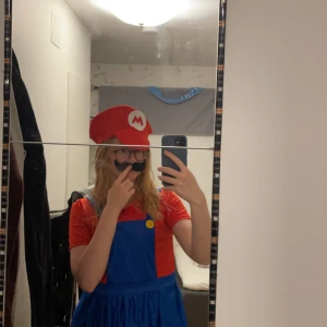Super Mario klänning - Super fin Super Mario klänning med tillhörande hatt och mustasch. Jättebra nu till halloween, HELT oanvänd. Beställde den nyligen men är lite kort till mig så säljer nu vidare. Köpt för 300kr 