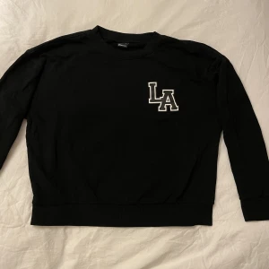 Svart hoodie - Svart hoodie med tryck.