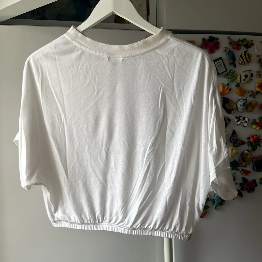 Croppad vit top i bomullsmaterial från Reebok   Använd fåtal gånger men är lite nopprig runt halsen om man kollar nära . T-shirts.