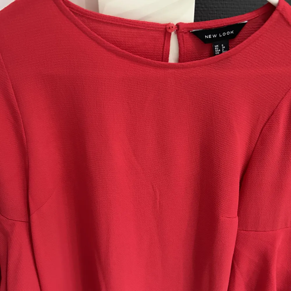 Klänning från new look i häftigt röd färg och volanger på armarna. Använd bara en gång, bekväm och normal i storlek.. Klänningar.