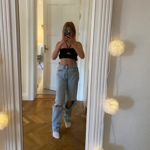 Högmidjade jeans från Gina tricot - Högmidjade jeans från Gina Tricot med hål på knäna. Ena hålet är lite mer upprivet. I storlek 34.