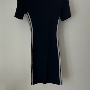 Klänning - Säljer en svart tajt klänning från Hm. Den är i väldigt fint skick och säljer eftersom den är förliten för mig. Det är str XS.💗💗Det finns också jätte cool reflex på sidorna som lyser t.ex när man är ute på kvällen. 90kr och du står för frakten💗🥰