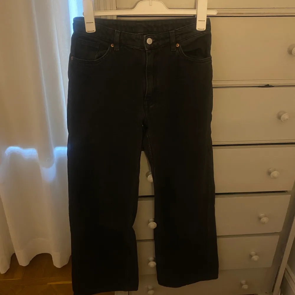 Ett par svarta utsvängda monki jeans. Jeans & Byxor.