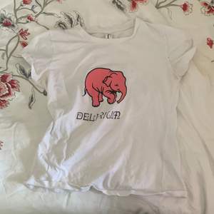 Säljer en t-shirt med rosa elefant tryck, den har ett litet hål på ärmen som man ser på bild nr2 men det syns knapp när man har tröjan på!