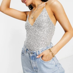 Silverfärgad body med paljetter - Tyvärr aldrig använd pga för liten storlek men passar utmärkt till temafester, nyår och framförallt sommaren. Helt slutsåld på ASOS hemsida!!! 