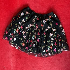Spring skirt black - Cute oversized skirt in black with colorful pattern of flower. It has several layers of textile with the last one that is transparant and makes the skirt oversized. 