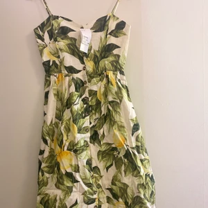 Klänning från h&m - Oanvänd med prislappen på. Lång klänning med knappar