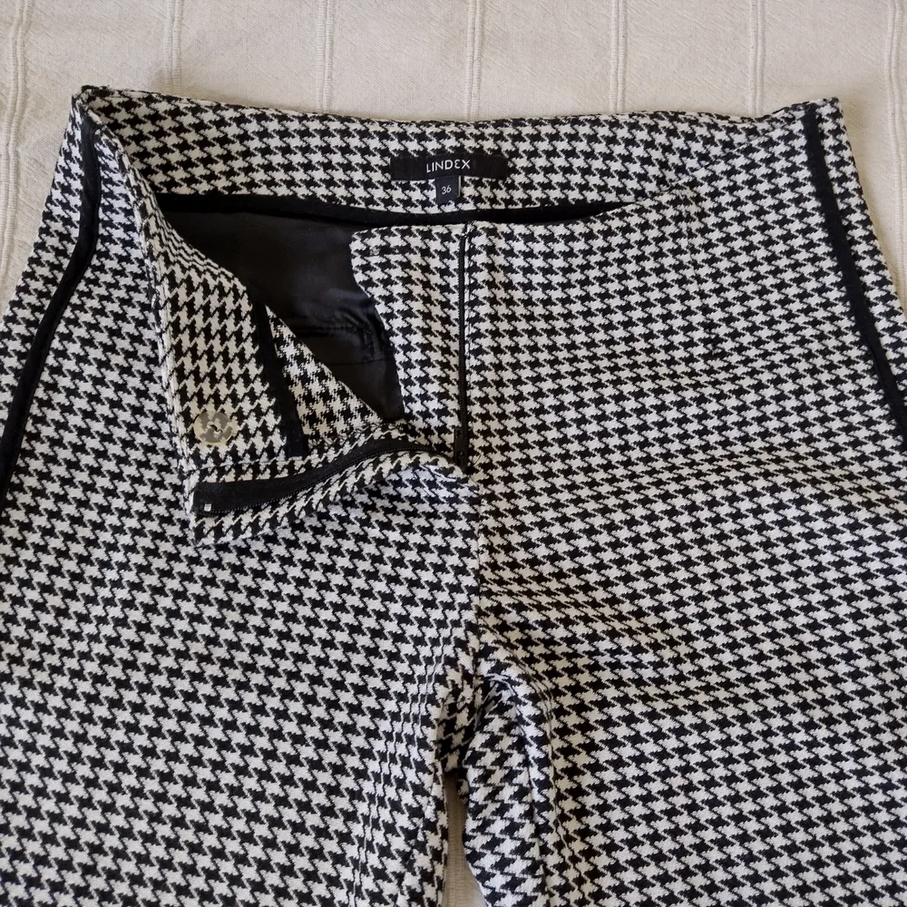 Mjuka, stretchiga byxor i hundtandsliknande mönster och med snygga detaljer. Svartvita och lite kortare i modellen. Använda ett par gånger och är som nya. 63% polyester 31% viskos och 6% elastan. Storlek 36.. Jeans & Byxor.