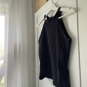 Linne med högre krage - Svart fint linne med högre krage som passar perfekt till alla tillfällen! Har använts länge så är lite nopprig (se bild)