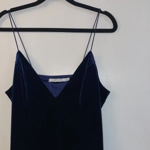 Super fin nyårsklänning - Finaste blåa nyårsklänningen i velvet som tyvärr bara kommit till användning en gång. Storlek M. Har försökt få till så rättvis färg på bilderna som möjligt. Frakt tillkommer