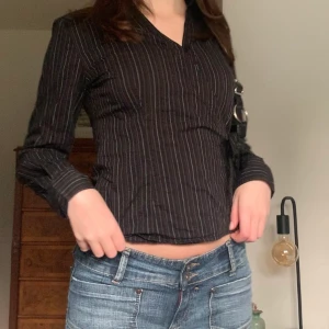 Randig skjorta - Svart figursydd skjorta men kritstrecksränder och v-ringning, originellt från Ellos! Knyts med band i sidan ❤️‍🔥