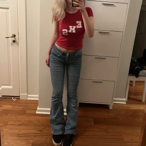 RÖD BABYTEE - En röd babytee med high school musical trycket, jättegullig och aldrig använd. Sitter som en smäck utan att vara obekväm. (Initialerna till east high school och signatur färgerna).💗💗💗💗💗💗